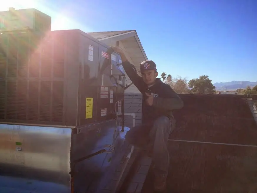 HVAC technician performing AC Tune-Up on a rooftop unit in Linthicum